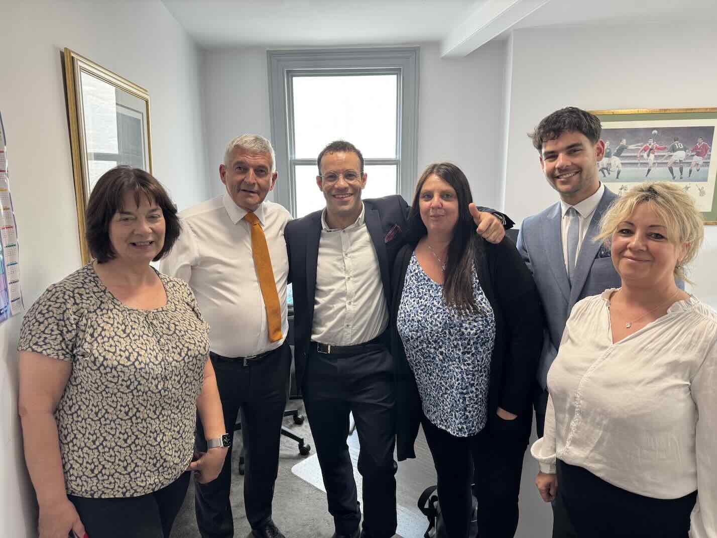 Taylor Wheeler with a client team in their office after a website launch